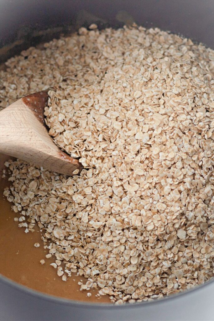 oatmeal poured on top of peanut butter mixture in pot