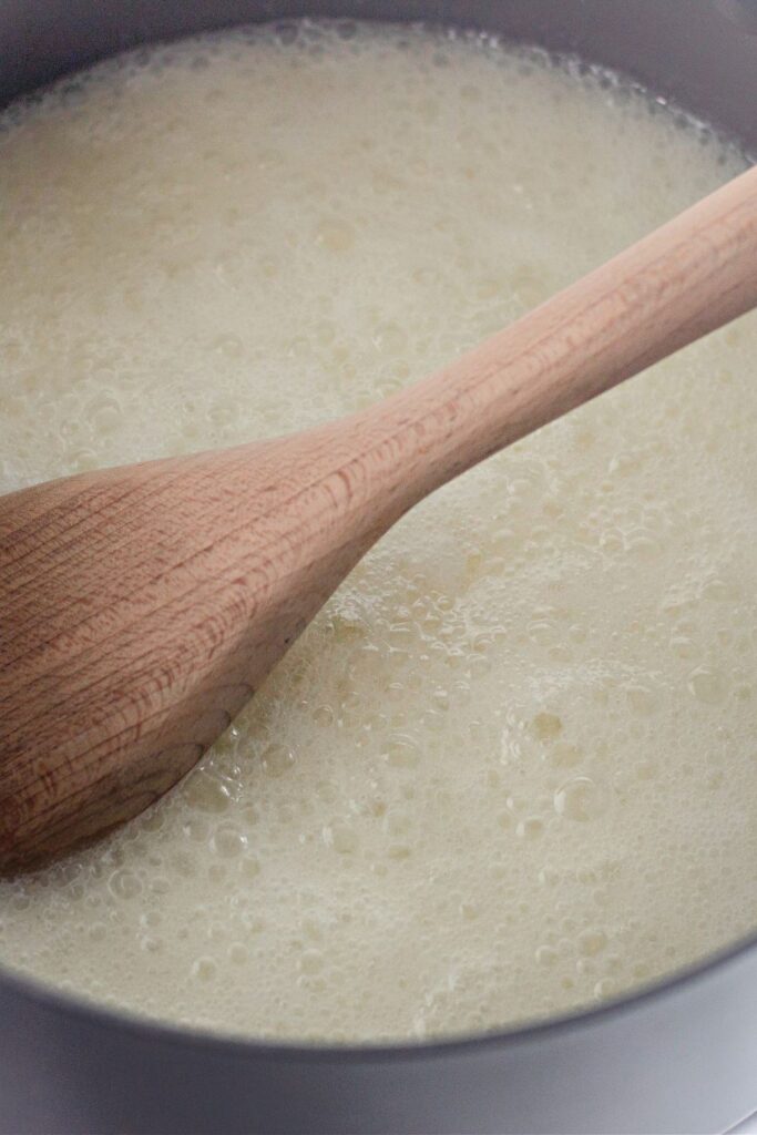 wooden spoon in pan with butter and sugar mixture that is melted