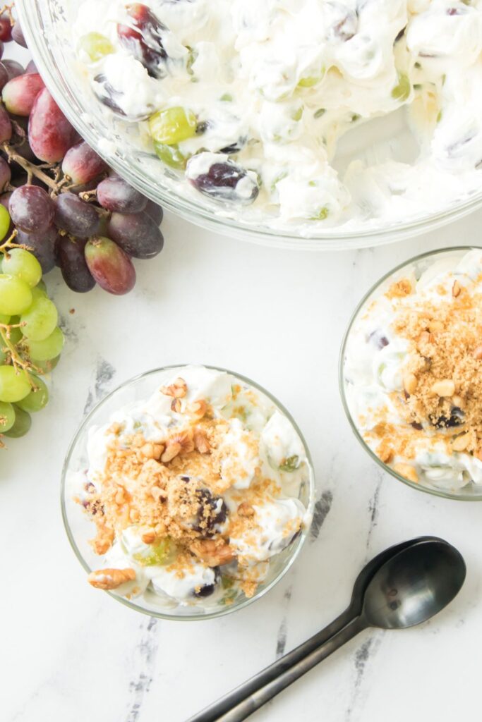 overhead shot of grape salad in bowls and big bowl of salad behind it 