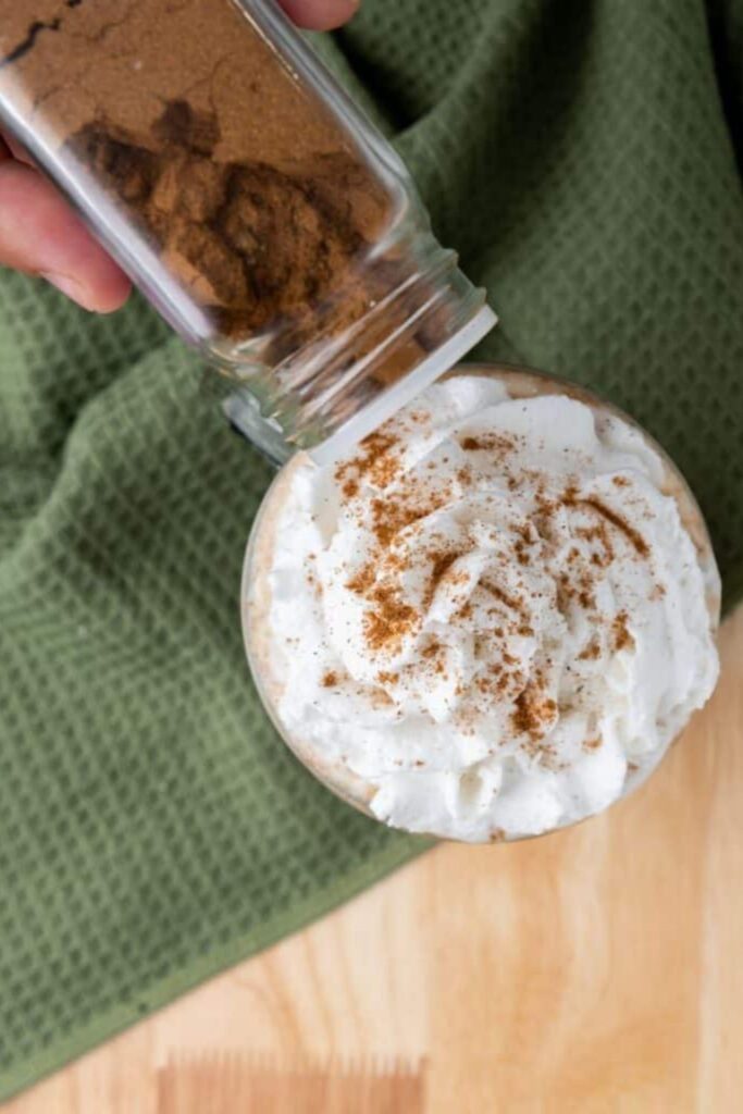 sprinkling cinnamon on latte