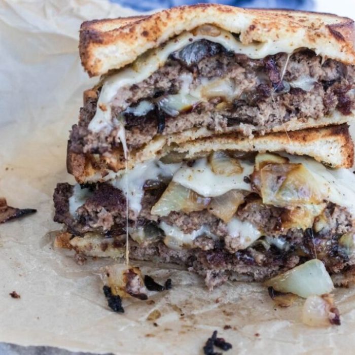 Blackstone Griddle Patty Melt Burger stacked on top of each other on table