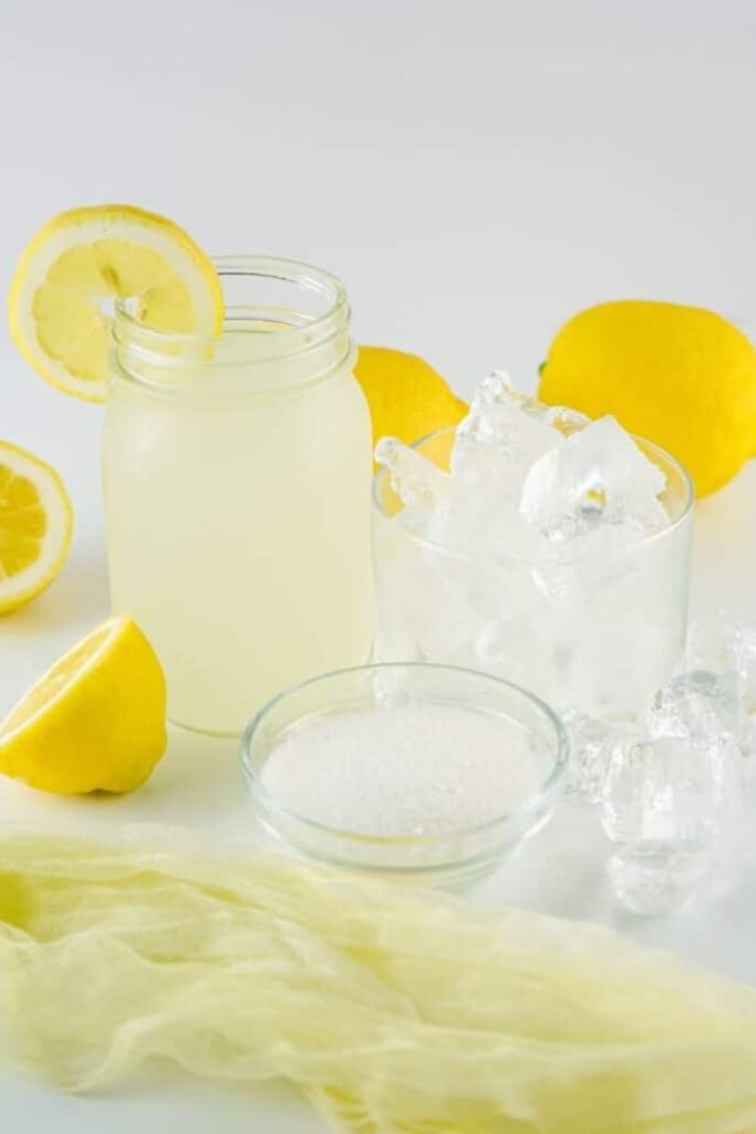 Lemonade Slushie ingredients on table with lemons around table
