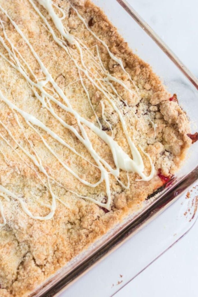 looking down on table to see a glass pan with Raspberry Crumble Bars inside