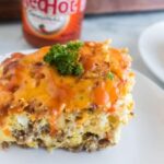 Sausage and Egg Casserole on a white plate garnished with parsley