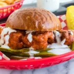 buffalo chicken sandwich in a basket with celery and carrots